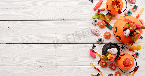 白色木质背景、顶视图的万圣节派对用五颜六色的糖果