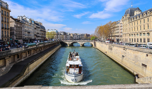 巴黎/法国 — 2019年4月5日：巴黎美丽的城市景观、横跨塞纳河的圣米歇尔桥和一艘载有游客的游船