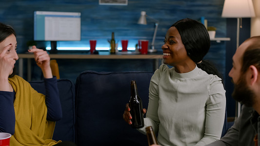 黑人妇女拿着啤酒瓶与朋友讨论