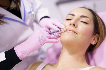 医生在女性面部注射透明质酸作为面部年轻化治疗。
