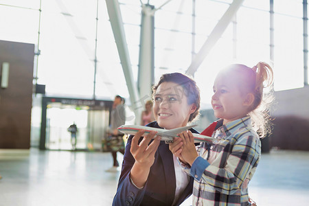 机场工作人员在机场与可爱小女孩玩耍时拿着飞机玩具的肖像