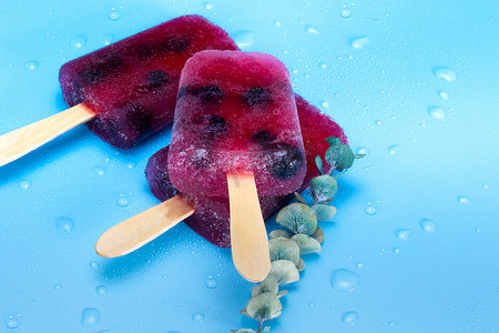 蓝色背景夏季的自制覆盆子和蓝莓冰淇淋顶视图，甜点，食品概念现代设计与复制空间色彩缤纷