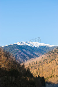 在罗马尼亚阿尔杰斯的 Rausor 湖和大坝拍摄的 Iezer-Papusa 山脉及其白雪皑皑的山峰和橙色自然的照片