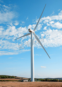 可持续资源摄影照片_阳光明媚的日子里，风力涡轮机在蓝天的衬托下
