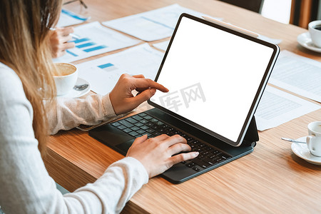 女性拿着数字平板电脑的裁剪图像，在咖啡店模拟屏幕阅读在线书籍，女性的手指点击便携式计算机通过 wifi 检查社交网络中的提要。