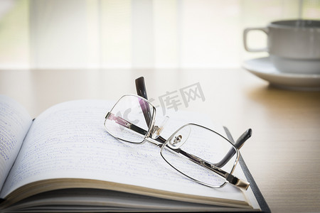 眼镜放在桌子上的书上