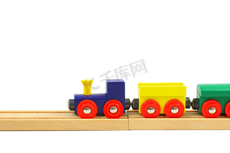 在白色隔离的铁轨上的木制火车玩具