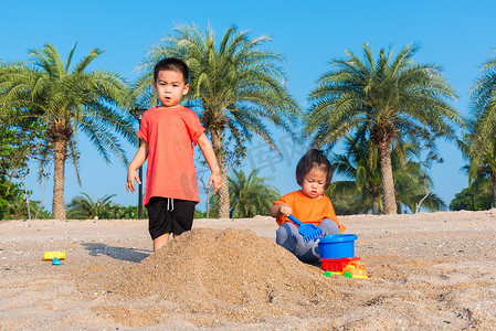 兄妹两个孩子有趣地挖沙玩具