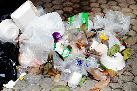 地板上的塑料垃圾堆、垃圾塑料废玻璃和吸管、塑料袋废物、垃圾泡沫托盘食品和干树叶