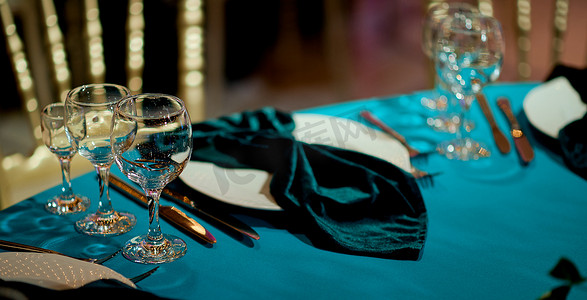 餐桌上放着空饮料杯和时尚的青色餐巾。