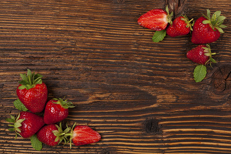 棕色桌子摄影照片_质朴的木制棕色桌子上的成熟草莓。