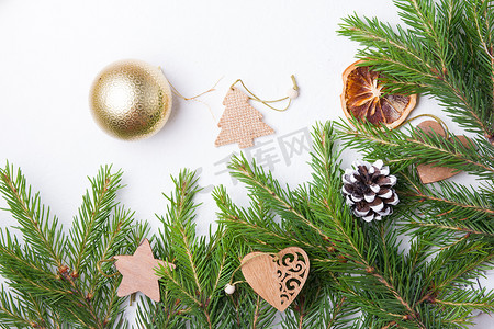 树枝状水系摄影照片_圣诞树金球和白色背景顶视图复制位置上的天然杉树枝，新鲜云杉树枝上的木制生态友好型圣诞树玩具