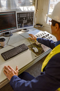 在工厂使用台式电脑的男性工程师