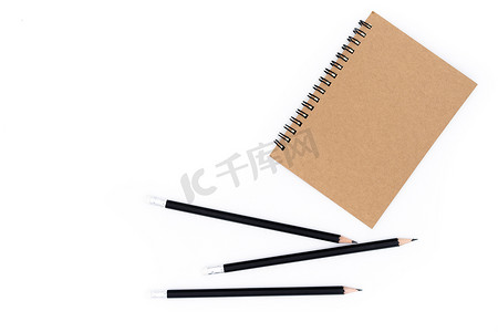 1 本棕色书，白色背景上有 3 支铅笔