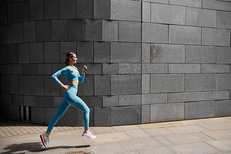 跑步运动的人摄影照片_美丽健康的年轻女子慢跑者正在户外跑步