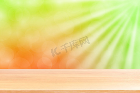 空木桌地板上柔和的绿色散景灯光束闪耀渐变背景，木板空在绿色散景彩色灯光上，彩色散景灯渐变软用于横幅广告