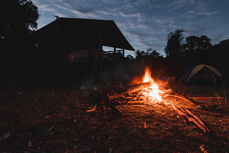 沙漠帐篷露营摄影照片_篝火与房屋和帐篷的阴影与晨光