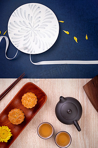 月饼秋天摄影照片_创意月饼月饼设计灵感，在中秋节享受月亮，在木桌概念、顶视图、平躺上享用糕点和茶