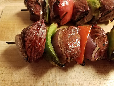 青椒牛肉摄影照片_牛肉和洋葱粘在木切板上