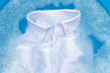 将衬衫浸泡在洗衣粉水中溶解。