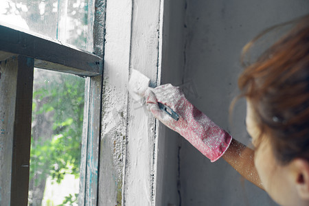 装修中摄影照片_有刷子油漆窗口的妇女家庭装修内部