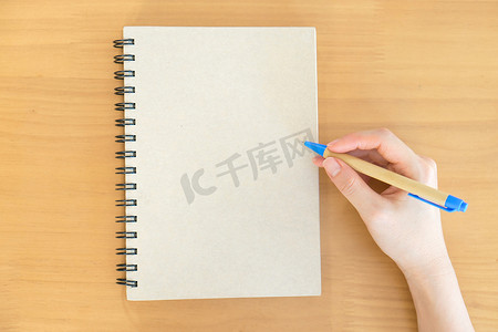 女性手用钢笔在笔记本上写字