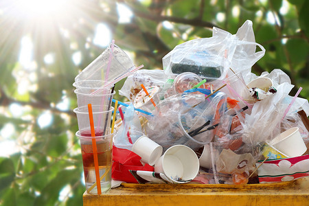 垃圾箱中的废塑料堆，垃圾满箱垃圾，塑料袋垃圾自然树阳光背景上的大量垃圾，垃圾许多特写