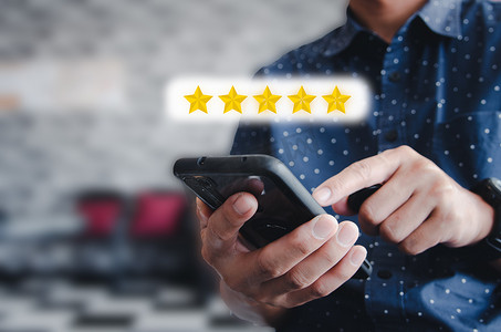 男子手持使用手机图标星级评级 5 星优秀评级或评论服务。