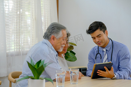 老人流感摄影照片_医生在他们家的客厅旁边向老人讲解老年妇女的健康状况。