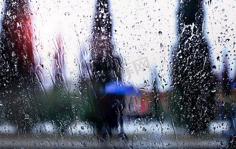 冬天窗户背景摄影照片_城市背景下的雨滴通过窗户的抽象图像