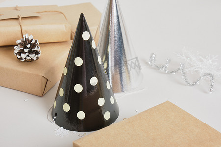 灰色背景的派对帽和礼盒，闪亮的新年或圣诞装饰，