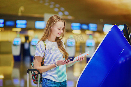 背着背包的旅游女孩，在国际机场携带行李，自行办理登机手续