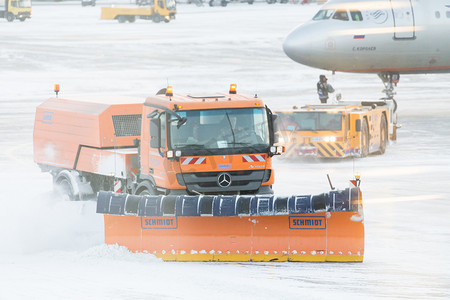 在暴风雪期间，除雪机从机场的跑道和道路上除雪，透过窗户看