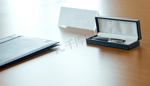 笔盒包装摄影照片_一个文件夹，一个昂贵的白色衬里皮笔盒和一个提手，是一个空名牌。