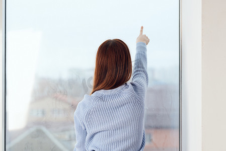 靠窗的女人梦幻般的样子在家里休息舒适