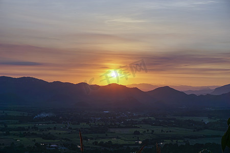 橘色蓝色摄影照片_山后的夕阳，天边有远山的橘色，收着反光的橘色。