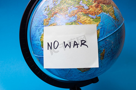 地球贴纸摄影照片_地球仪和标有“没有战争”铭文的贴纸