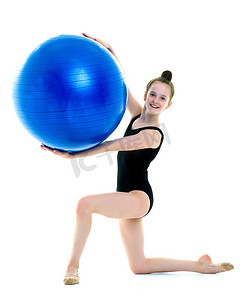 健身的小女孩摄影照片_的小女孩在健身的大球上锻炼。