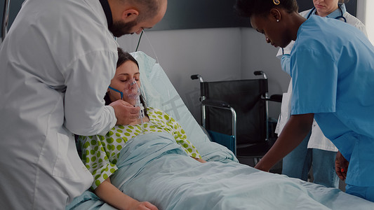 临床团队监测病妇戴氧气面罩分析呼吸系统疾病