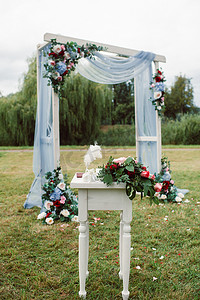 鲜花拱门摄影照片_在绿色草坪上的街道上举行的婚礼。婚礼用鲜花拱门装饰