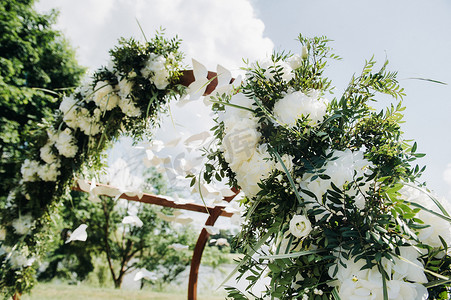 鲜花拱门摄影照片_在绿色草坪上的街道上举行的婚礼。婚礼用鲜花拱门装饰