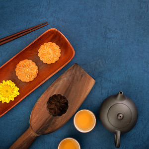中中秋节摄影照片_中秋节蓝色背景月饼的简约布局，创意食品设计理念，顶视图，平躺，复制空间。