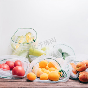 不同的新鲜水果和蔬菜装在可重复使用的袋子里。