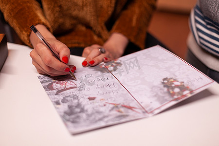 圣诞手写摄影照片_圣诞节期间，女性手写圣诞贺卡给家人的特写