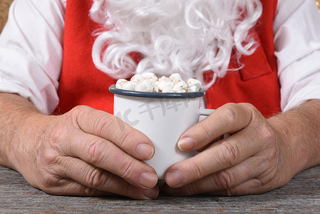圣诞老人拿着一杯热新鲜热巧克力的特写