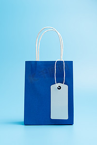 蓝色购物或礼品袋隔离在蓝色背景