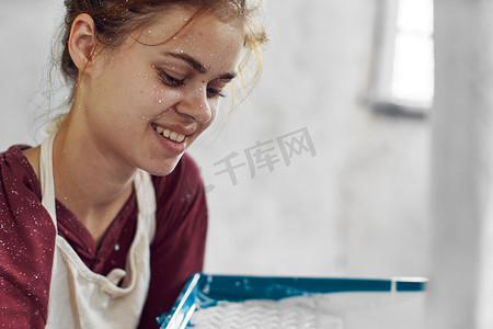 开朗的女人在房屋装修内部粉刷一个房间