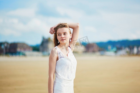 阳光沙滩摄影照片_美丽的年轻女子在沙滩上享受阳光