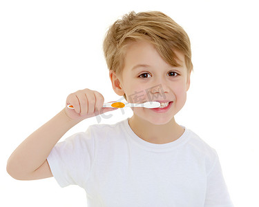 一个小男孩正在用牙刷刷牙。