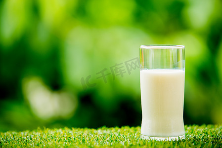新鲜的草地摄影照片_草地上的牛奶玻璃